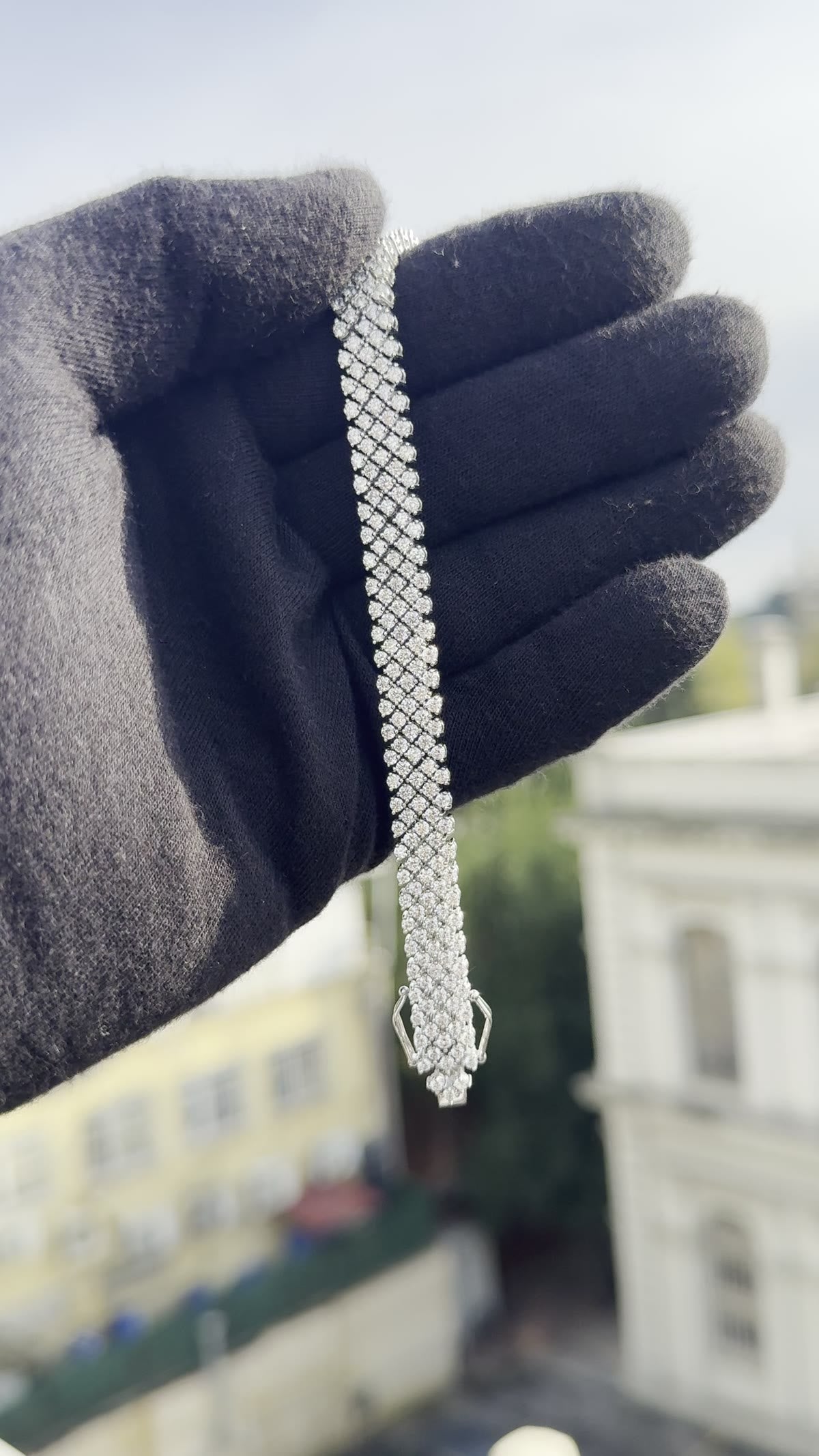Wide lattice diamond bracelet laid over a gloved wrist